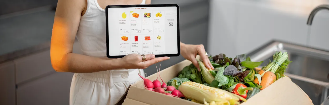 Kobieta z tabletem odbierająca zamówienie warzyw i owoców ze sklepu online